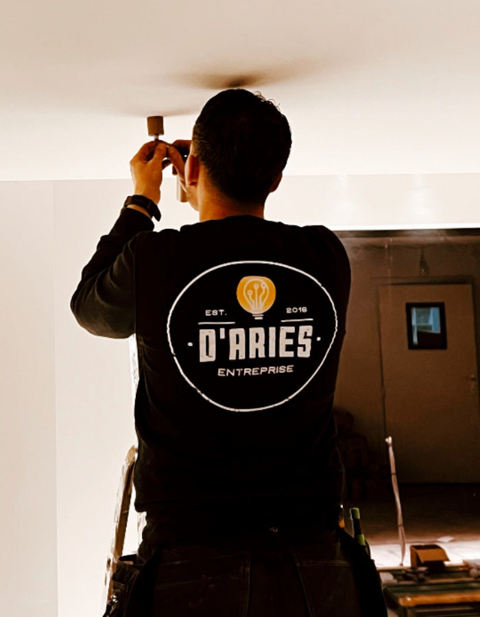 Photo d'un collaborateur de l'équipe DARIES entreprise qui installe un luminaire